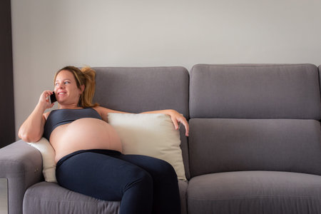 Young Pregnant Woman Speaking On The Phone so relaxing. Portrait.