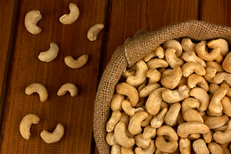 Healthy food. Cashew nut in sack bag on wood table backgroundの写真素材