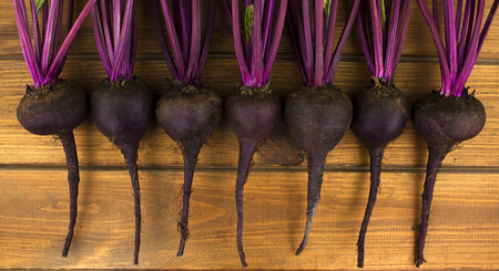 Organic red beets with green leaves on an old wooden table. Rustic styleの写真素材