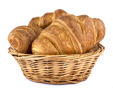 Crispy fresh croissants in a basket isolated on whiteの写真素材