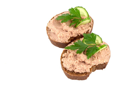Bread with homemade chicken pate, isolated on white background with parsley and cucumber