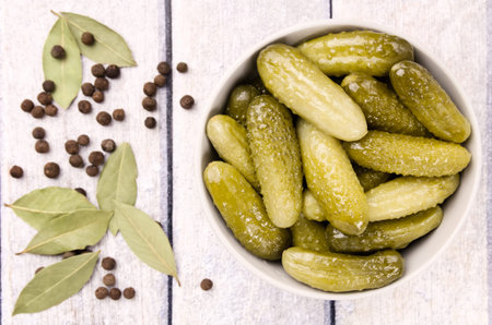 Pickled cucumbers gherkins on a wooden rustic table. Pickled cucumbers in a bowl