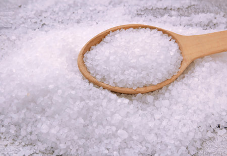 Sea salt on a wooden table. Coarse sea salt for cooking, large crystals of sea salt for adding to...