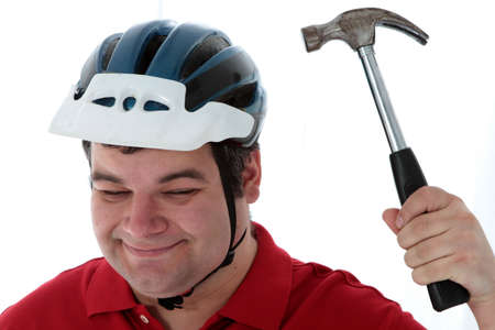 Men smacks is hammer on a helmetの写真素材