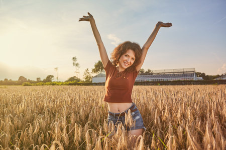 Happy woman in golden wheatの写真素材
