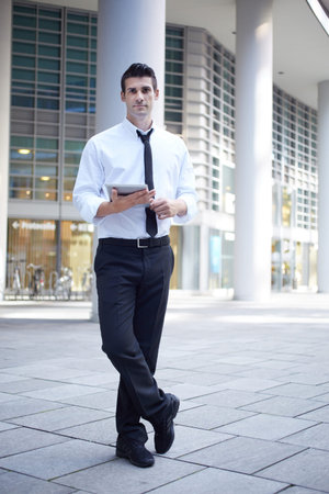 businessman using digital tablet outside office buildingの写真素材