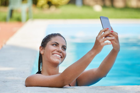young beautiful woman taking a selfie in swimming pool