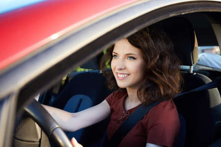 young woman driving a new carの写真素材