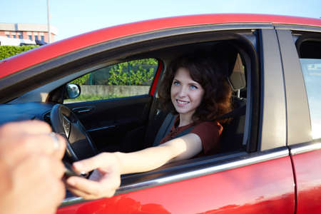 young woman driving a new carの写真素材