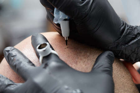 professional tattooist making permanent make up tricopigmentationの写真素材