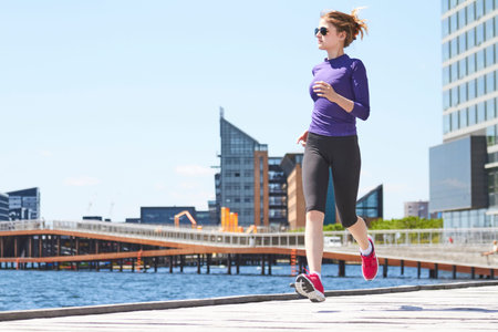 Female fitness athlete running training living healthy lifestyle on Copenhagen Promenadeの写真素材