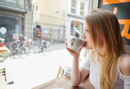 Woman drinking coffee at street cafe