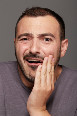Toothache - suffering young man with teeth problems