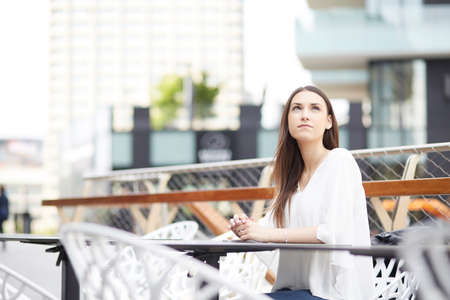Lady with shades on writing in your diary on terrace with coffee asideの写真素材