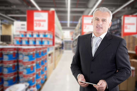 smiling adult businessman manager in a supermarketの写真素材