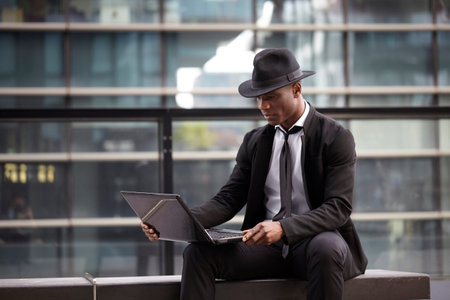 Serious business man working on laptop computer outdoorsの写真素材
