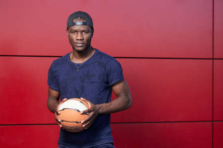 Portrait of a young African American man holding a basketball.の写真素材