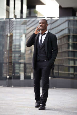 Young businessman calls on mobile in downtownの写真素材