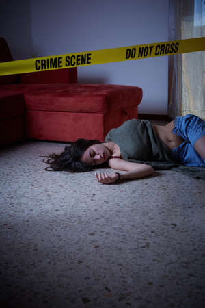 Crime scene imitation. Lifeless woman lying on the floorの写真素材