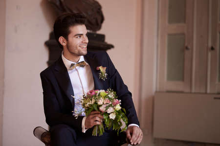 groom looking and thinking  on a sofaの写真素材