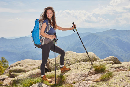 traveling girl with backpack hiking in the mountains, eco tourism