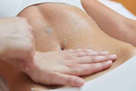 Body Scrub. Beautiful Blonde Gets a Salt Scrub Beauty Treatment in the spa Salonの写真素材
