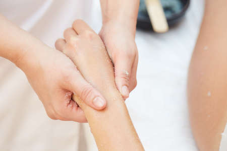 Woman Getting a Salt Scrub Beauty Treatment on hands in the Health Spaの写真素材