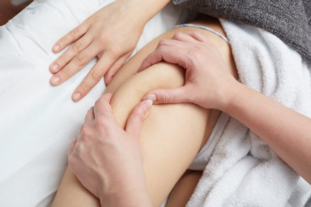 Therapist applying pressure on female leg
