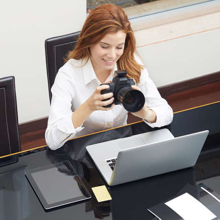 Portrait of happy female photographer checking photos in cameraの写真素材
