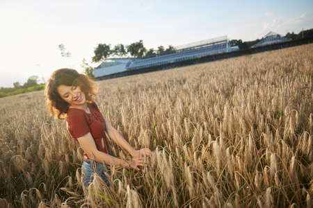 a beautiful woman standing on wheat fieldの写真素材