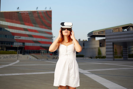 Happy woman using virtual reality headset in urban environment