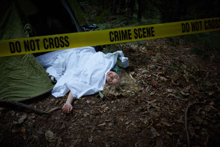 young woman lying dead in a forest after rapeの写真素材