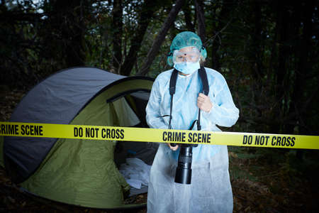 Forensics researcher photographing a blood  at a murder sceneの写真素材