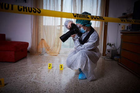 Forensics researcher photographing a blood  at a murder sceneの写真素材