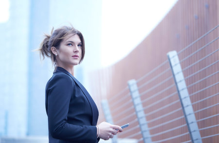 pretty businesswoman talking to mobile in urban environment