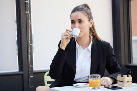 young businesswoman talking to mobile and drink a cup of coffeeの写真素材
