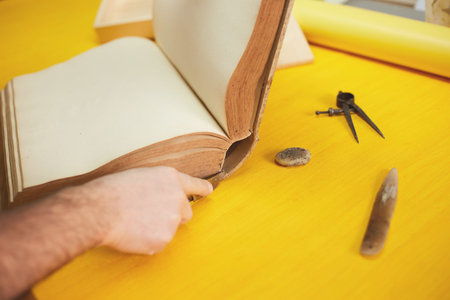 book binder restores old book in craft workshop