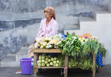 Bondowoso,Indonesia-October 10,2018: Old woman wait for vegetables buyer in traditional marketsのeditorial素材