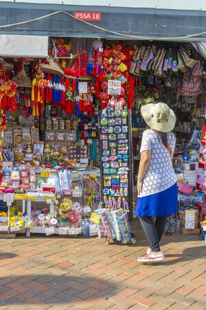 Woman traveler wearing hat looking at souvenir items in Chinatown at Singapore city downtown travelling in Singapore concept photoのeditorial素材