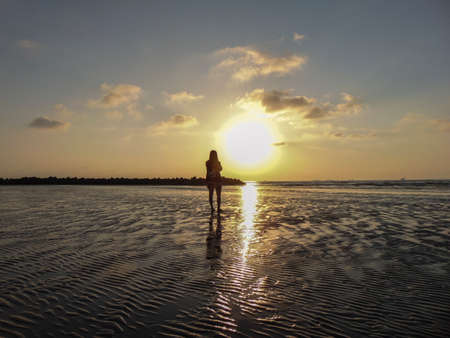 the silhouette of a woman on the beach in the morningのeditorial素材