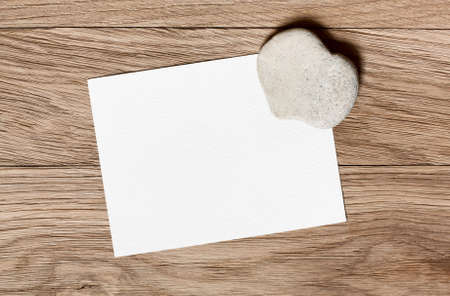 Stone in the shape of a heart and a piece for congratulations on a wooden backgroundの写真素材
