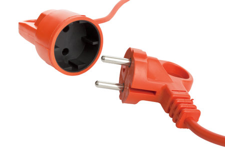 Orange electric power cable with plug and socket isolated on white background. selective focus