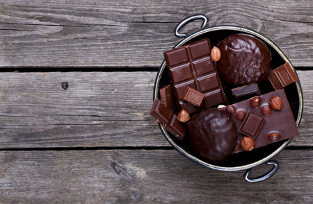Vase with chocolate, nuts on a gray wooden background