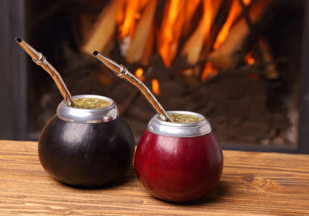 Hot mate in calabashes on the background the fireplaceの写真素材