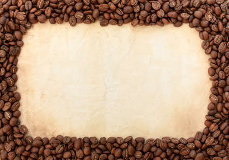 Background of black coffee beans and old paper, place for textの写真素材