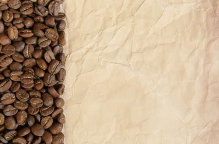 Background of black coffee beans and old paper, place for textの写真素材