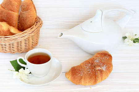 Breakfast - croissants and jasmine tea on a light wooden backgroundの写真素材