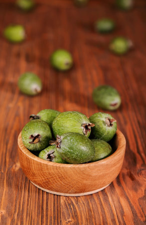 Fruits of feijoa in a wooden bowl on the tableの写真素材