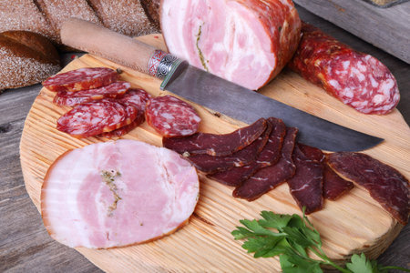 Sliced cold meats on a cutting board, top view