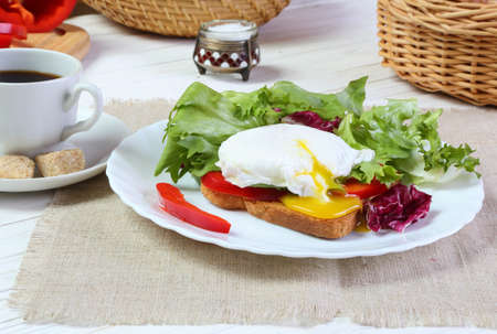Breakfast - poached egg, toast and salad on white wooden tableの写真素材